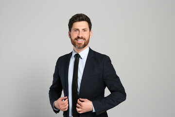 Handsome real estate agent in nice suit on grey background