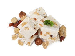 Pieces of delicious nougat, nuts and mint on white background, top view