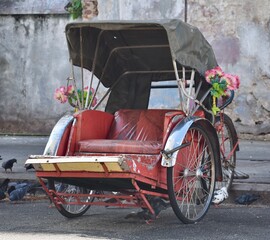 Beautifully decorated rickshaw resting on the street in Penang, Malaysia
