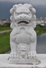 Fototapeta na wymiar Small guardian lion on a bridge near a temple in Taiwan