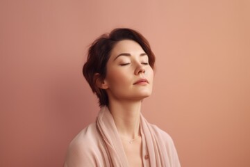 Portrait of a beautiful young woman with closed eyes on a pink background