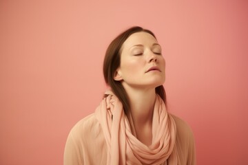Portrait of a beautiful young woman with closed eyes on a pink background