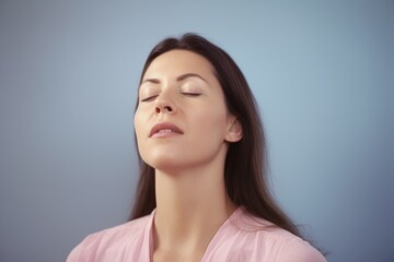 Portrait of a beautiful young woman with closed eyes on a blue background