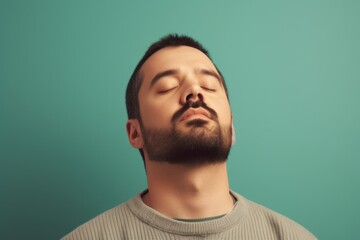 Fototapeta premium Young man with closed eyes on a green background. Toned.