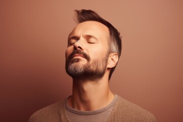 Fototapeta premium Portrait of handsome bearded man with closed eyes. Studio shot.