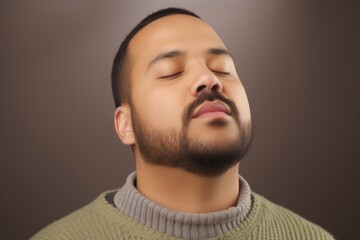 Naklejka premium Portrait of a young man with closed eyes, on gray background