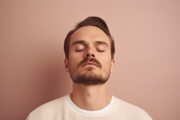 Obraz premium Portrait of a young man with closed eyes on a pink background