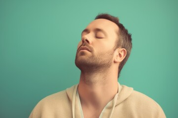 Obraz premium Young man sleeping with eyes closed on a green background. Toned.