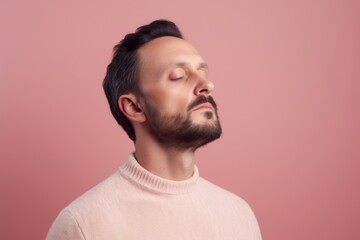 Obraz premium Portrait of a handsome young man with beard and mustache in a pink sweater