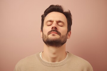 Obraz premium Portrait of a young man with closed eyes on a pink background
