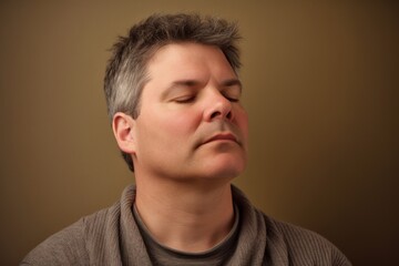 Fototapeta premium Group portrait photography of a man in his 40s practicing mindfulness, sophrology, relaxation & stress-reduction wearing a cozy sweater on pastel background. Generative AI