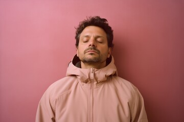 Obraz premium Young man sleeping in a pink hoodie on a pink background.