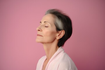 Fototapeta premium Mature woman with closed eyes on pink background, focus on eyes