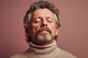 Obraz premium Portrait of an old man with gray hair in a turtleneck on a pink background