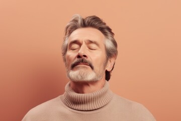 Obraz premium Portrait of handsome senior man with gray hair wearing beige sweater