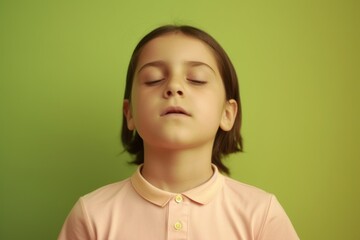 Portrait of a little girl with closed eyes on a green background