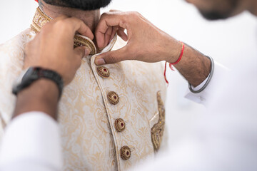 Indian groom's white wedding outfit close up
