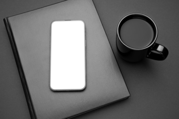 Mockup display. Mobile cell phone blank screen. Smartphone technology. Office equipment. Office workplace, black notebook, cup of tea or coffee. Mock up device for application, website design project.