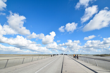 ラカゼルヌからモンサンミッシェルへ続く橋を歩いて渡る点景の観光客