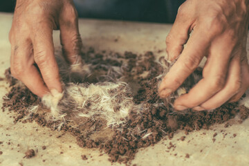 Craftsman working the clay with his hands to make figures for spectacular ornaments with clay, water, plants and mix everything.