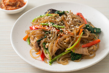 japchae or stir-fried Korean vermicelli noodles with vegetables and pork topped with white sesame