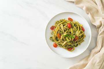 fettuccine spaghetti pasta with pesto sauce and tomatoes