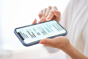 スマートフォンでメッセージのやりとりをする女性の手元