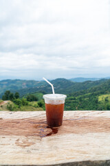 americano coffee on wood table with Mountain hill View background