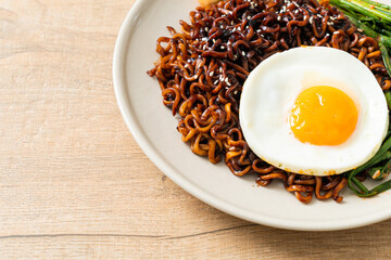 dried Korean spicy black sauce instant noodles with fried egg and kimchi