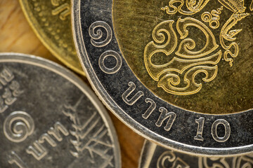 Group of Thai coins with ten-baht coin on top. Macro, close up.