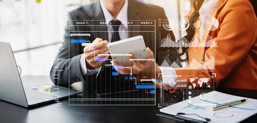Businessman hand Project manager working and update tasks and Gantt chart scheduling virtual diagram.with smart phone, tablet and laptop
