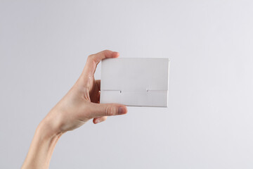 Hand holding bank card box on gray background