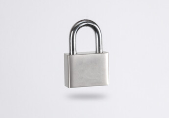 Metal padlock levitating on gray background with shadow