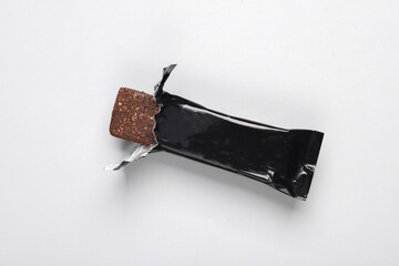 Black packaging of a chocolate or protein bar on gray background