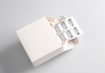 White box mockup with blister pills on gray background. Template for design