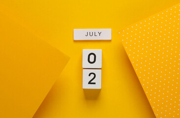 White calendar cubes with date july 02 on yellow background. Creative layout