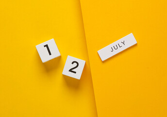 White calendar cubes with date july 12 on yellow background. Creative layout
