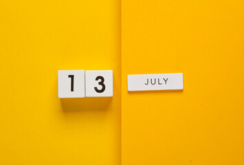 White calendar cubes with date july 13 on yellow background. Creative layout