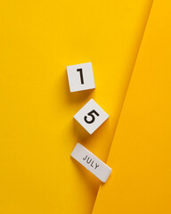 White calendar cubes with date july 15 on yellow background. Creative layout