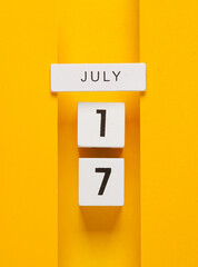 White calendar cubes with date july 17 on yellow background. Creative layout