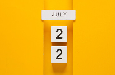 White calendar cubes with date july 22 on yellow background. Creative layout