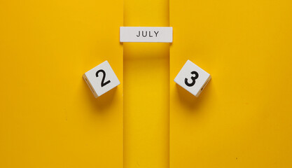White calendar cubes with date july 23 on yellow background. Creative layout