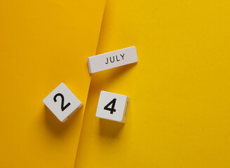 White calendar cubes with date july 24 on yellow background. Creative layout