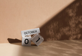 Wooden white block calendar with date october 01 on beige background with shadow. Creative layout, planning, holiday