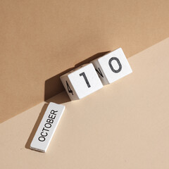 Wooden white block calendar with date october 10 on beige background with shadow. Creative layout, planning, holiday