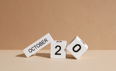 Wooden white block calendar with date october 20 on beige background with shadow. Creative layout,...