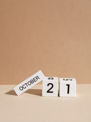 Wooden white block calendar with date october 21 on beige background with shadow. Creative layout, planning, holiday