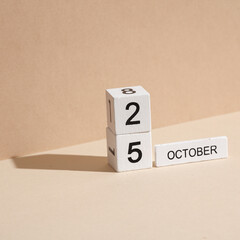 Wooden white block calendar with date october 25 on beige background with shadow. Creative layout,...