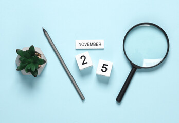Business concept, deadline. Calendar with the date november 25 and stationery, office supplies on a blue background.