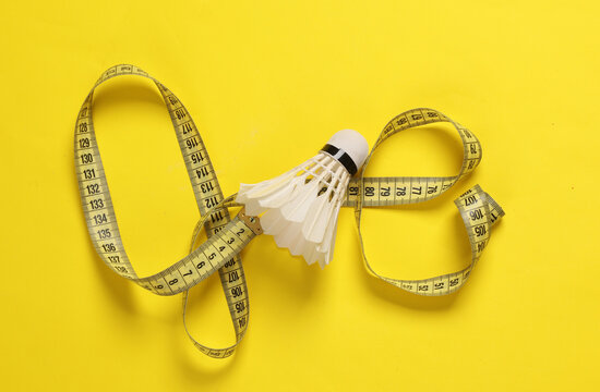 Shuttlecock with a measuring tape on a yellow background. Active rest, weight loss